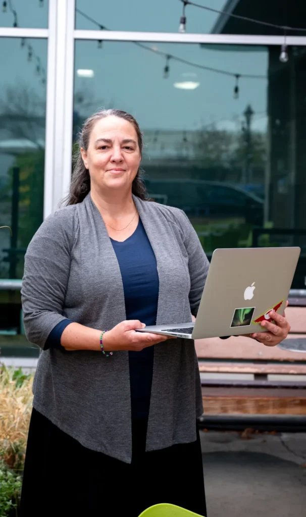 Business consultant working on a laptop outdoors, preparing bookkeeping and client reports.