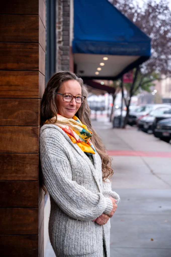 Urban building exterior with wood paneling and blue awning.